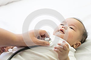 Doctor exams Asian newborn baby with stethoscope in the hospital