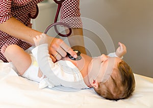 Doctor exams infant with stethoscope