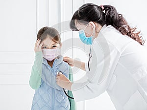 Doctor exams little girl with stethoscope photo