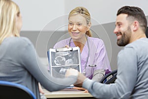 Doctor explain ultrasound result to asian couple at hospital