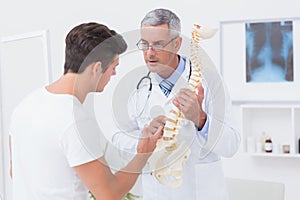 Doctor explaining anatomical spine to his patient