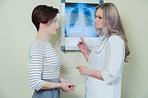 Doctor explaining diagnosis to her female patient analysing x-ray photography