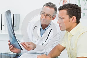 Doctor explaining lungs xray to patient in office