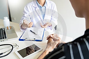 Doctor explaining for patient and showing medical records informations and diagnosis patient symptoms in a consultation and