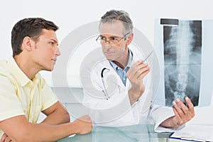 Doctor explaining spine xray to patient in office