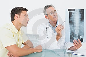 Doctor explaining spine xray to patient in office