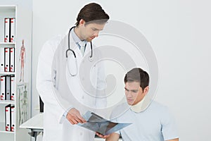 Doctor explaining spine xray to patient in office