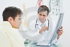 Doctor explaining spine xray to patient in office