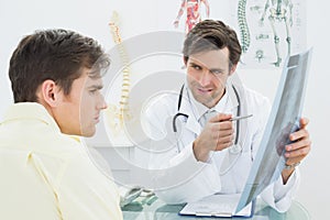 Doctor explaining spine xray to patient in office