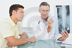 Doctor explaining spine xray to patient in office