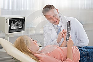 Doctor Explaining Ultrasound Scan To Pregnant Woman