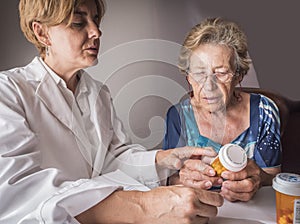Doctor explains to elderly daily dose of medication photo