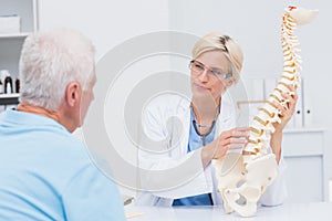 Doctor explaning anatomical spine to male patient