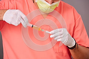 Doctor extracting plasma with syringe from tube