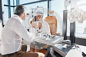 Doctor, eye exam or mature woman consulting for eyesight at optometrist or ophthalmologist. Senior customer testing