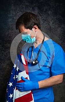 Doctor with face mask nursing the American flag.