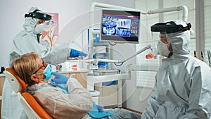 Doctor with face shield pointing on stomatological monitor