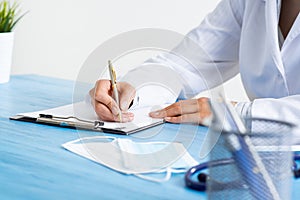 Doctor filling patient history list at clipboard