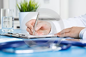 Doctor filling patient history list at clipboard