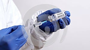 Doctor Fills Injection syringe with Vaccine COVID-19