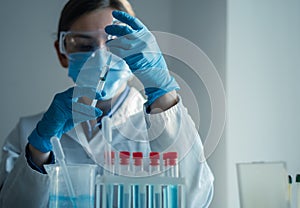 The doctor fills the syringe with medicine. A nurse in a hospital laboratory prepares for injection