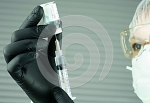 A doctor fills a syringe with a vaccine. Antiviral vaccine. Save the infected patient. Help the patient. Qualified medical work