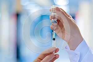 The doctor fills a syringe with vaccine . photo