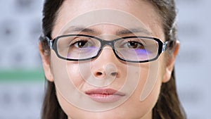 Doctor fitting eye glasses on smiling woman face, vision correction, health care