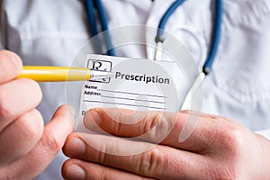 Doctor in foreground holding sample of prescription or recipe for drug, other hand indicates designation of prescription medicatio photo