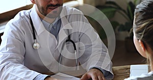 Doctor general practitioner shaking hands with female patient.