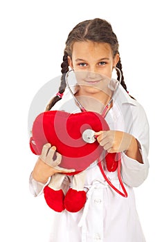 Doctor girl examine heart toy