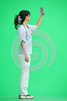 Doctor girl, on a green background, full-length, with a phone