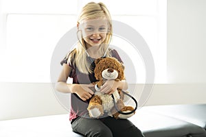 A doctor girl playing and cure bear at the pediatric