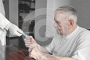 Doctor gives a thermometer to measure the temperature of an older sick patient. A gray-haired old man takes the thermometer from