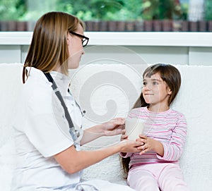 Doctor gives to drink to the sick child