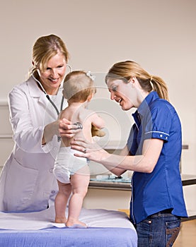 Doctor giving baby girl checkup in doctor office photo