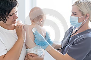 Doctor giving baby girl checkup in doctor office