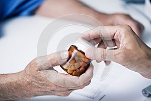 Doctor giving a bottle of pills to a senior man