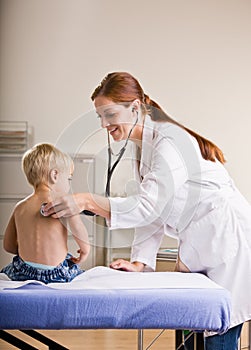 Doctor giving boy checkup in doctor office