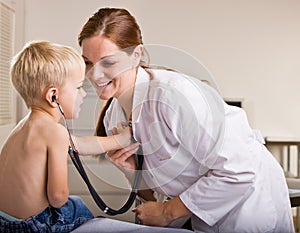 Doctor giving boy checkup in doctor office