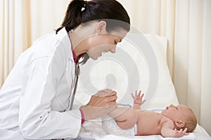 Doctor giving checkup to baby in exam room photo