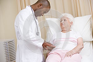 Doctor giving checkup to woman in exam room photo