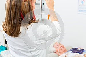Doctor giving clinic senior patient drip infusion