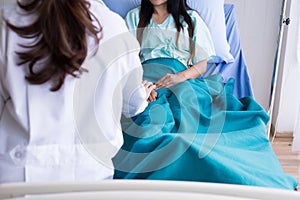 Doctor giving a consultation encouragement to patient,Hands doctor holding and reassuring her female patient in hospital room