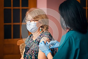 Doctor giving Covid vaccine to senior woman