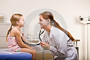 Doctor giving girl checkup in doctor office