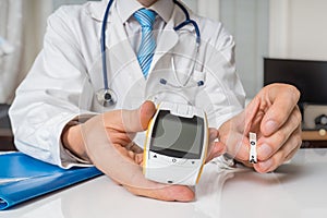 Doctor is giving glucometer to diabetic patient to measure blood sugar. Diabetes concept photo
