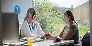 Doctor giving hope. Close up shot of young female physician leaning forward to smiling lady patient holding her hand in