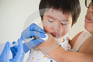 Doctor giving an injection vaccine to a girl. Little girl crying