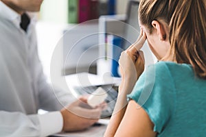 Doctor giving medical help to sick patient with bad headache or migraine.